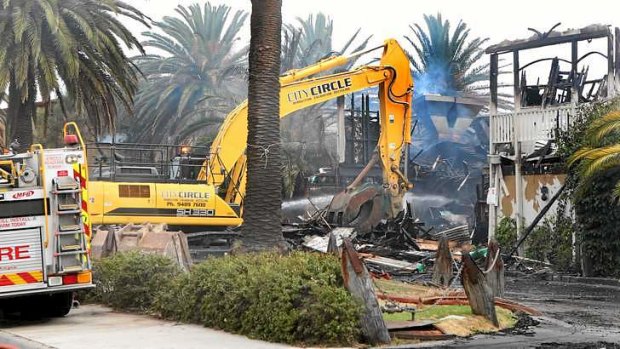 A crane removes the roof of the still-smouldering Stokehouse.