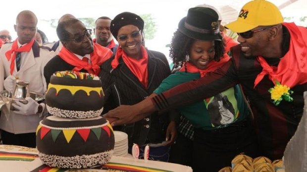 President Robert Mugabe, centre left, his wife Grace, daughter Bona and her fiance Sam Chikoore cut his birthday cake during celebrations to mark his 90th Birthday.