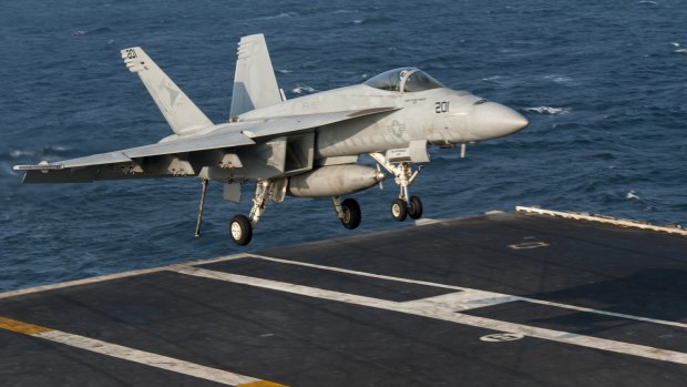 Air strikes continue ... A US fighter jet lands on the flight deck of the aircraft carrier USS Carl Vinson in the Persian Gulf. 
