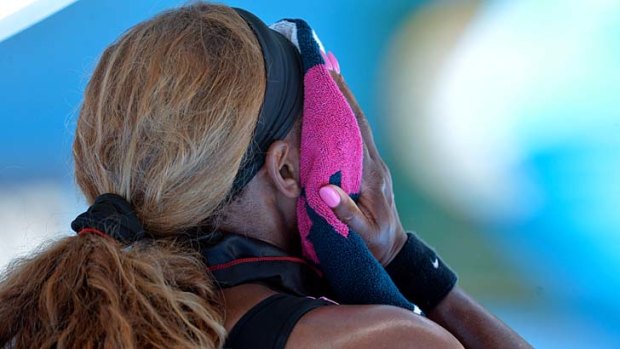 Serena Williams wipes her face with a towel during her second-round match against Vesna Dolonc.