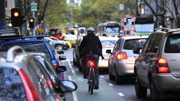 A cyclist navigates his way through the traffic on Collins st.