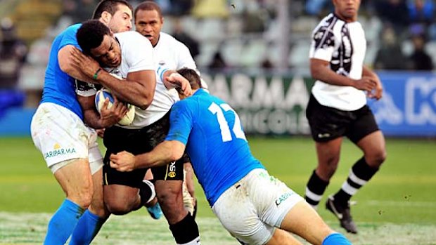 Fiji's Napolioni Nalaga (C) vies with Italy's Alberto Sgarbi (R) and Robert Barbieri.