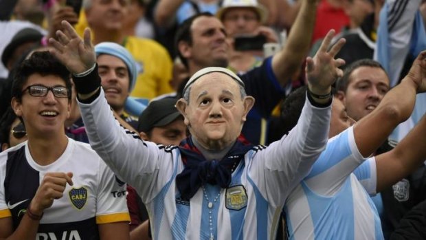 Divine intervention: An Argentina fan bearing a mask of Argentinian Pope Francis cheers during the semi-final football match between Netherlands and Argentina.