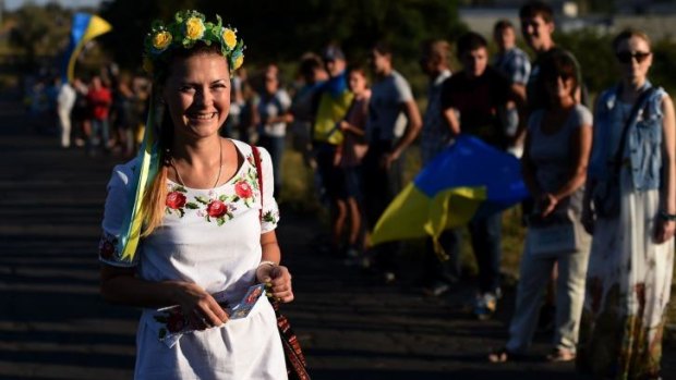 Flower power: Ukrainian loyalists demonstrate by the last checkpoint controlled by Ukraine's army on the eastern side of Mariupol on Saturday.