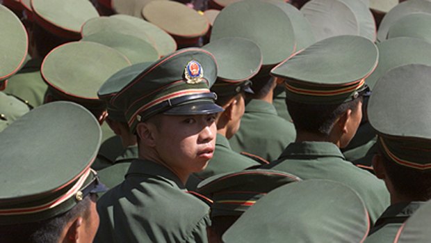 A Chinese military policeman looks back while others watch a local festival in Lhasa in this 2002 file photograph.