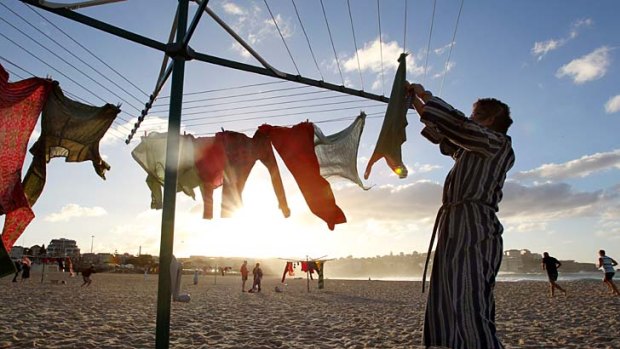 Coming out in the wash . . . a woman hangs up washing on Bondi Beach as part of a surreal artwork representing the impact of encroaching urbanisation on the Aussie backyard.