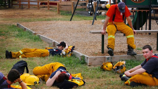 Exhausted buyt unbeaten: CFA firefighters resting at Arthur's Creek yesterday.
