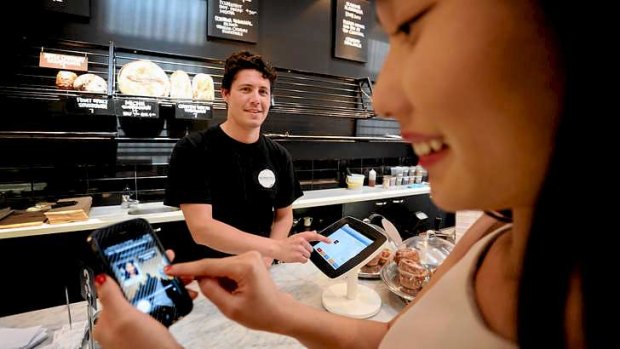 Lydia Feng pays for coffee from Stefan Villalobos using the Paypal instore payment method at Sonoma bakery in  Alexandria.