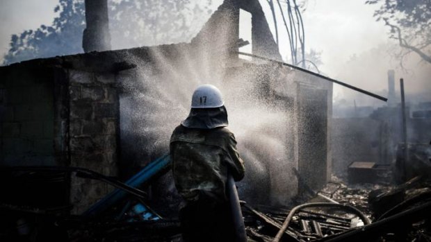 A fireman tries to extinguish a fire after shelling in Donetsk.