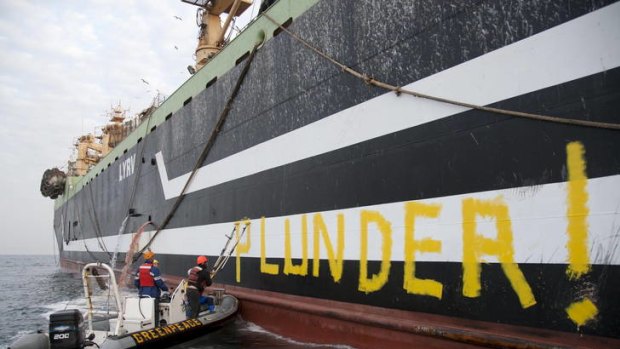 Tagged ... Greenpeace activists write on the side of the Margiris in the Atlantic off Mauritania.
