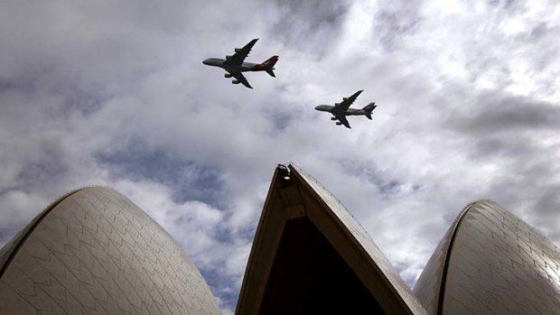 A Qantas Airways (left) and an Emirates Airlines Airbus A380 fly over the Sydney Opera House. Can Sydney airport handle more superjumbos?