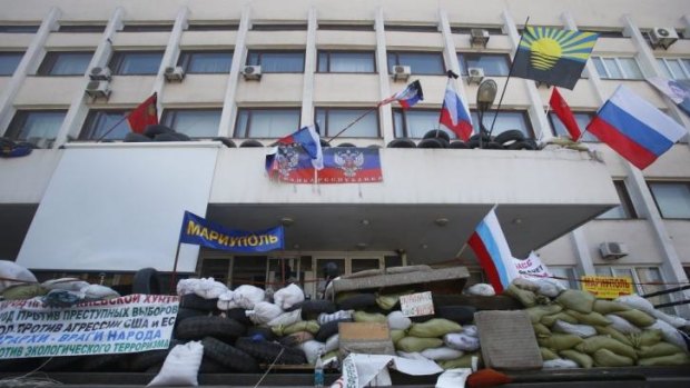 A barricade in front of the city hall as flags meant to represent the Donetsk Republic fly alongside Russian flags in Mariupol.