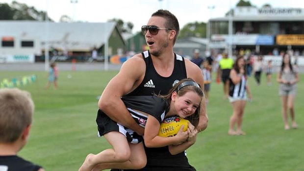 Wrapped up: Dale Thomas makes light work of this Magpie fan in Wangaratta.