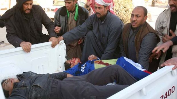 Iraqis load the bodies of teenagers killed in the Karbala bombings on a pick-up truck.