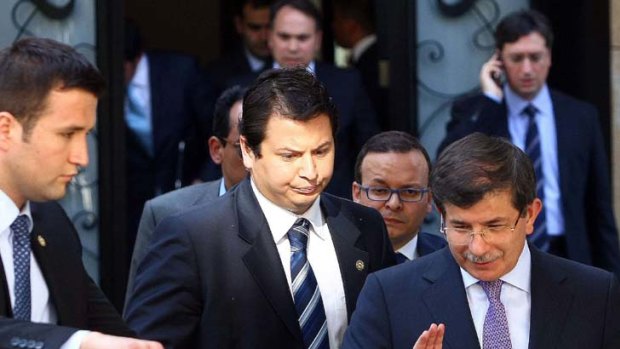 Weighing its response ... Turkey's Foreign Minister Ahmet Davutoglu, right, leaves a meeting focused on Syria with army generals after claiming the Turkish jet shot down by Syria was done so in international airspace.