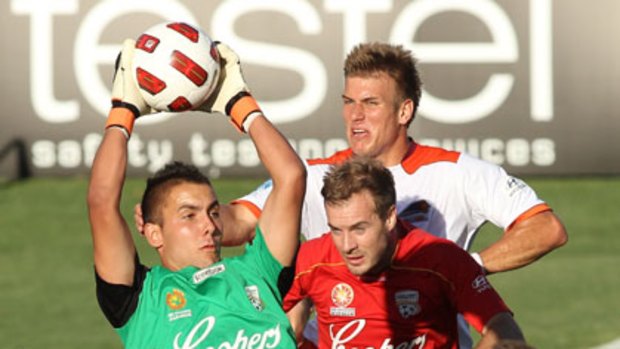 My ball ... Adelaide Keeper Mark Birighitti shows a safe pair of hands to thwart a Brisbane Roar attack in last night's top of the table clash.