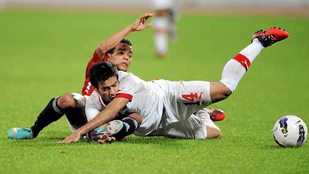 Mahmud al-Ajmi of Bahrain for and Hussein Ahmed Hussein of Yemen dive for the ball.