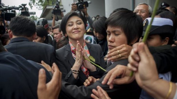 Thai Prime Minister Yingluck Shinawatra receives roses from her supporters.