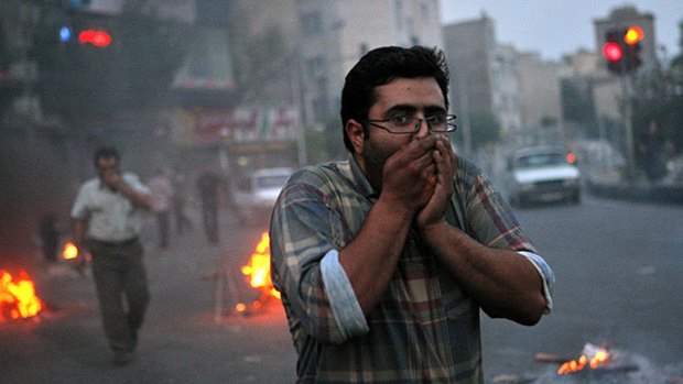 Iranian protesters cover their face from tear gas during clashes with riot police in Tehran in June 20, 2009.