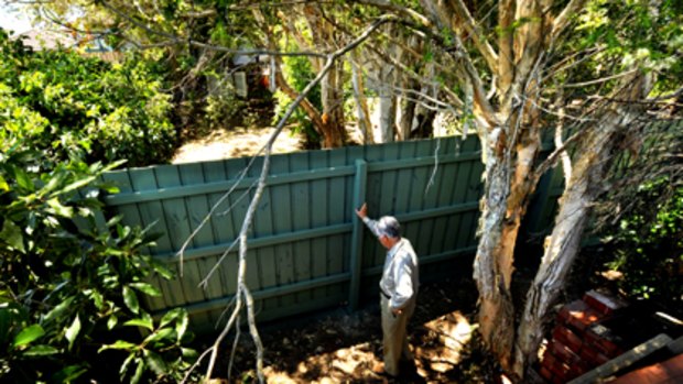 Alan Muir inspects a new fence that was put on his property with the assistance of Mick Gatto.