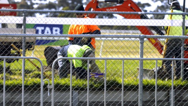 Track trouble ... workers fix the hole in the track at Werribee.