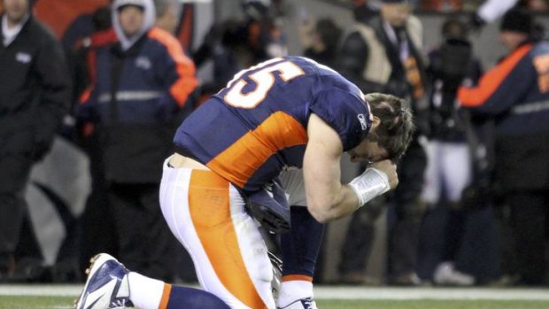 Devout Christian ... Tim Tebow prays after the Broncos defeated the Steelers in overtime on Sunday.