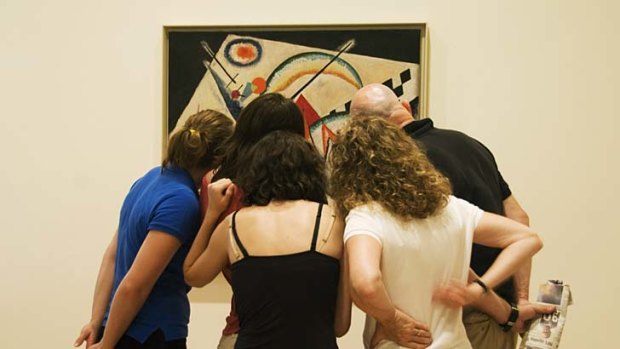 Visitors view a Kandinsky painting in the Peggy Guggenheim Collection.