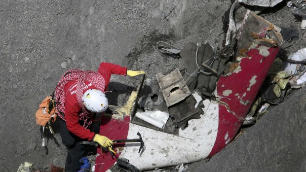 A French rescue worker inspects the remains of the Germanwings Airbus A320 at the site of the crash.