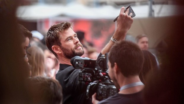 Actor Chris Hemsworth takes a selfie on the red carpet at the Thor screening.