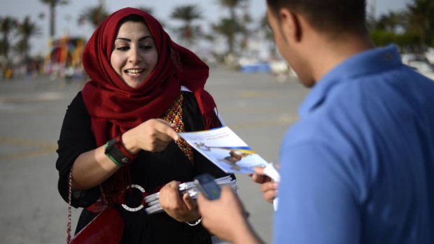 A supporter of Libya's Justice and Construction Party hands out leaflets at Martyrs' Square in Tripoli.