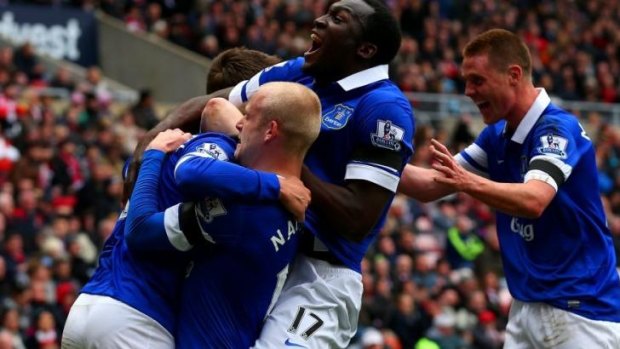 Steven Naismith, Romelu Lukaku and James McCarthy of Everton celebrate after Brown scores an own goal.