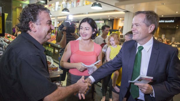 Fruiterer Jim Mousikos welcomes Opposition Leader Bill Shorten and Griffith Labor candidate Terri Butler to his fruit shop at Carindale.