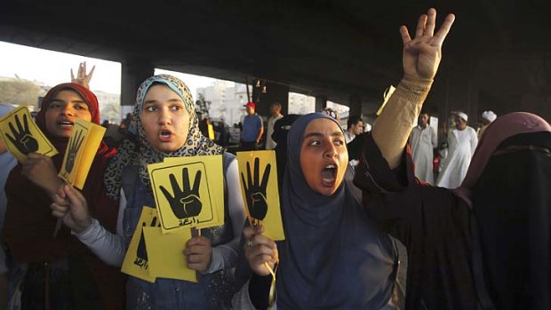 Sustained protests: Supporters of ousted President Mohamed Mursi show the "Rabaa" or "four" gesture, in reference to the police clearing of Rabaa al-Adawiya protest camp on August 14.