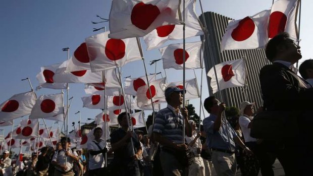 Members of the nationalist movement "Ganbare Nippon" march  with Japanese national flags while paying tribute to the war dead near Yasukuni Shrine.