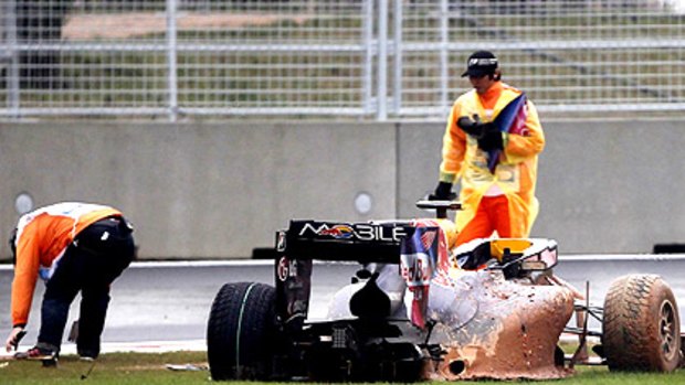 Track marshalls recover debris from around Mark Webber's car.