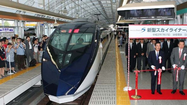Officials celebrate the opening of the new railway line at Nippori Station in Tokyo.