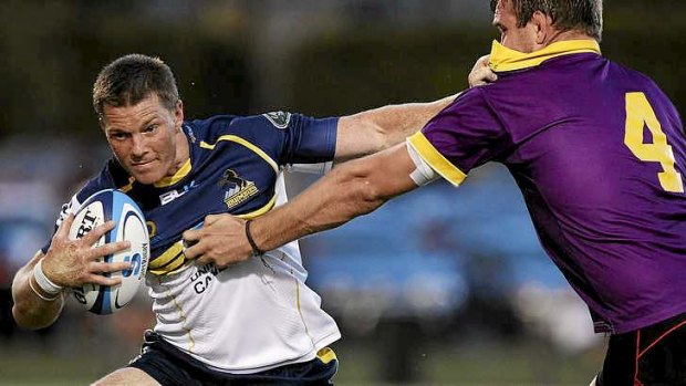 Two tries ... Clyde Rathbone of the Brumbies palms off Gareth Clouston of the ACT XV.