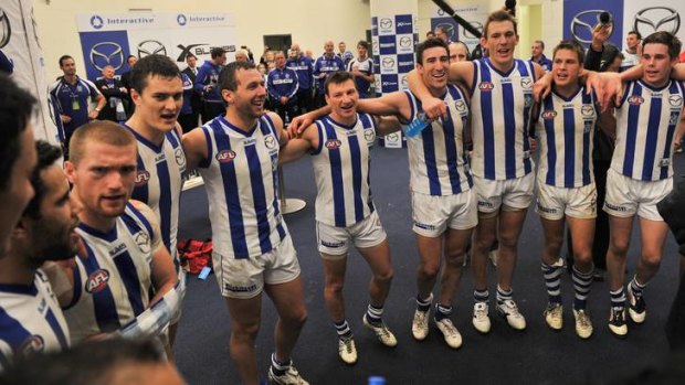 North Melbourne players sing the club song in celebration after defeating the Western Bulldogs at Etihad Stadium.