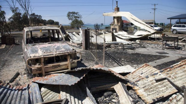 The charred remains of a car and houses at Dunalley on the east coast of Tasmania.