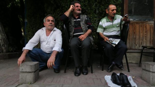 'He is perfect': Mustafa Sahin (left), Yilmaz Noyan and Ramazan Tuysuz (right) with their friend's shoes in Kasimpasa, the neighbourhood of Istanbul where Recep Tayyip Erdogan grew up.