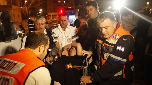 An Israeli woman is evacuated following a rocket attack by Palestinian militants from the Gaza Strip in the southern Israeli city of Beersheva.