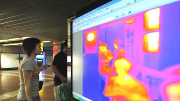 Passengers go through a thermal scanner at Jakarta's international airport. Thermal scanners will be used at eight Australian international airports from today.