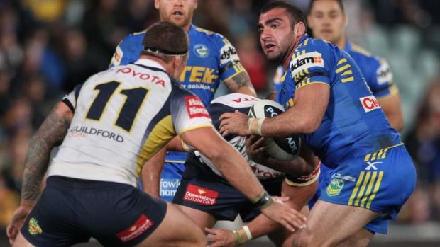 Leading by example: Parramatta co-captain Tim Mannah runs the ball into the teeth of the Cowboys defence on Saturday night.