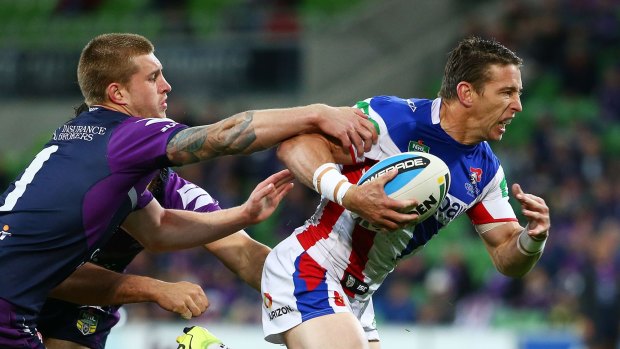 Kurt Gidley of the Newcastle Knights beats the tackle of Cameron Munster to open the scoring in the clash with Melbourne Storm at AAMI Park on Monday night.