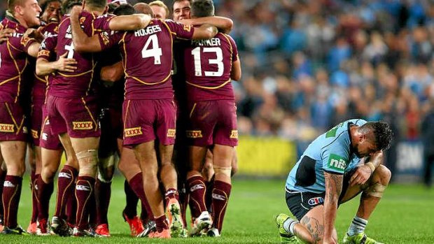 Andrew Fifita of the Blues feels the pain of defeat as the Maroon players celebrate.