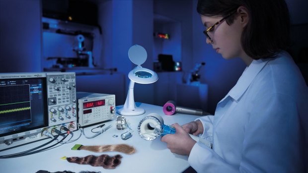 A Dyson engineer performs hair testing on a prototype of the new Supersonic hairdryer. 