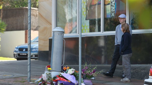 Flowers left for a pedestrian killed after being hit by a bus at an intersection in Beecroft.