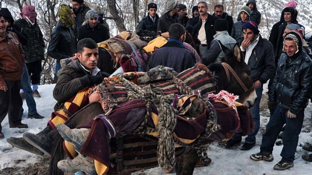 Bodies are mounted on to donkeys after Turkey's air force attacked smugglers who had been misidentified as Kurdish separatist fighters on the border with Iraq.