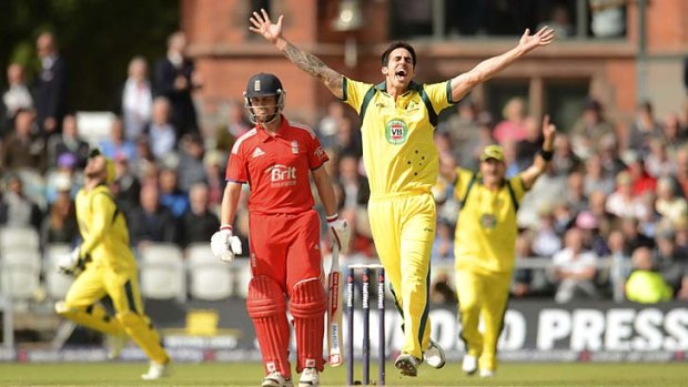 On target: Mitchell Johnson celebrates after capturing the wicket of Jonathan Trott at Old Trafford.
