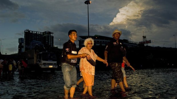 Rescuers help evacuate an elderly Bangkok resident.